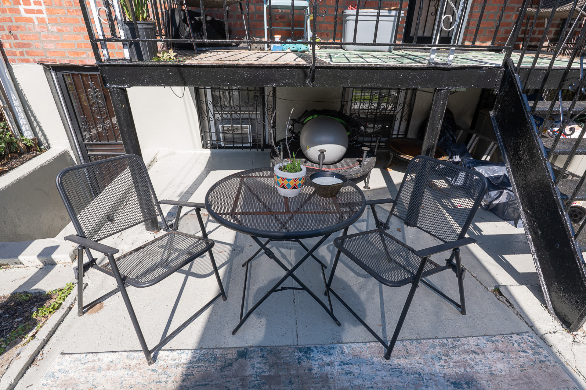 Shaded patio bistro set beside the private garden-level entrance